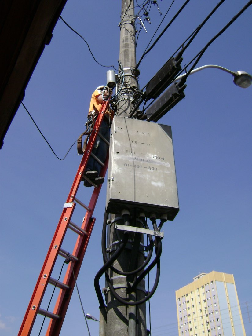 Eletricista trabalhando em campo em Araxá, Minas Gerais, exemplo de profissional que preenche ordem de serviço no celular durante o atendimento