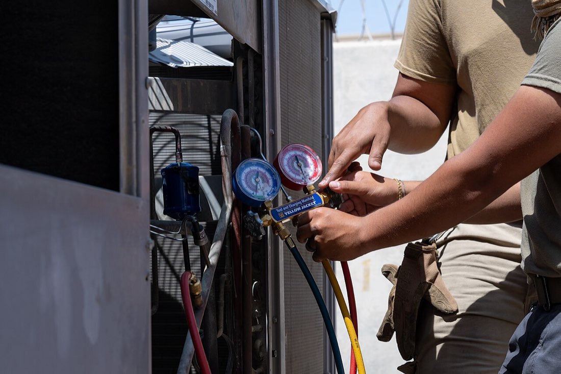 Equipe de técnicos de climatização em manutenção de campo