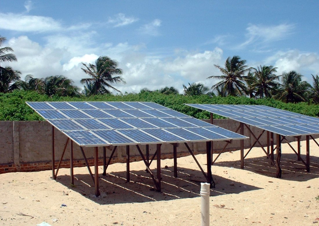 Instalação de painéis de energia solar fotovoltaica no litoral do Ceará, com coqueiros ao fundo, exemplo de serviço de campo precificado por BDI quando é obra ou empreitada